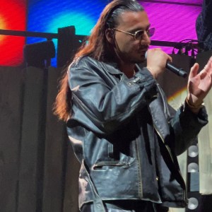 Apache 207 singt in einer schwarzen Lederjacke.