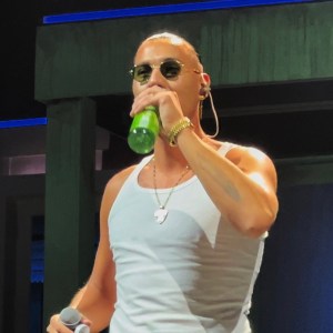 Apache 207 trinkt etwas auf seinem Konzert in Mannheim. Dabei sieht man sein Feder Tattoo am linken Unterarm. 